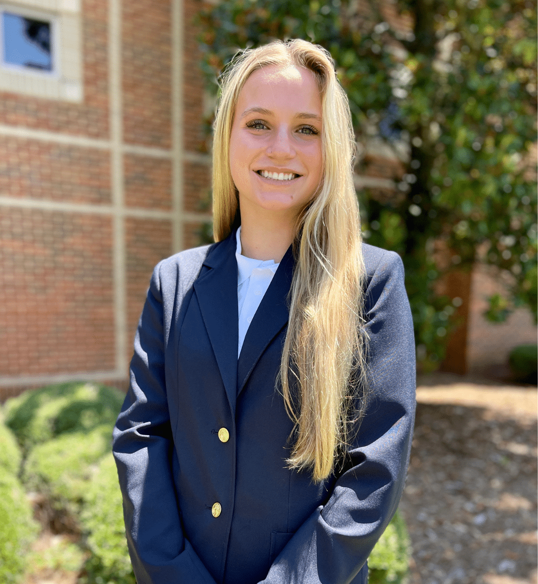 a person wearing a suit and tie smiling at the camera