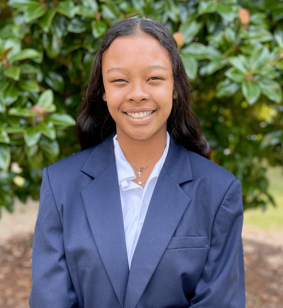 a person wearing a suit and tie smiling at the camera